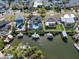 Waterfront property featuring a pool, private dock with boat lift, lush greenery, and neighboring houses at 6606 Dolphin Cove Dr, Apollo Beach, FL 33572