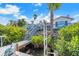 Waterfront backyard featuring a private dock with boat lift, lush greenery, and inviting stairs to backyard deck at 6606 Dolphin Cove Dr, Apollo Beach, FL 33572