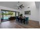 Bright dining room with modern fan, dining table set, and sliding doors that lead to a screened patio and a private pool at 6606 Dolphin Cove Dr, Apollo Beach, FL 33572