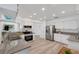 Bright kitchen with white cabinetry, stainless steel appliances, granite counters, and plank flooring throughout at 6606 Dolphin Cove Dr, Apollo Beach, FL 33572