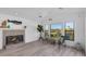 Bright living room features a fireplace, plank flooring, and a lovely view of the outdoor living area and canal at 6606 Dolphin Cove Dr, Apollo Beach, FL 33572