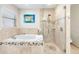 Modern bathroom features tub, glass shower, and decorative tiling at 8640 Chadwick Dr, Tampa, FL 33635