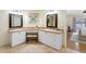 Bright bathroom featuring dual sinks, butterfly art, and a makeup vanity with direct access to main bedroom at 8640 Chadwick Dr, Tampa, FL 33635