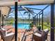 Inviting screened-in pool area with comfortable seating and a view of the lake at 8640 Chadwick Dr, Tampa, FL 33635