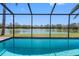 Screened-in pool with scenic lake view, offering a serene outdoor living space at 8640 Chadwick Dr, Tampa, FL 33635
