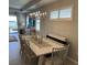 Elegant dining room featuring plantation shutters, a modern chandelier, and a calming lake view at 953 Crosswind Ave, Sarasota, FL 34240
