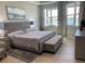 Serene main bedroom with a plush bed, soft gray tones, and scenic water views from large windows at 953 Crosswind Ave, Sarasota, FL 34240