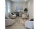 Cozy sitting room with neutral tones, four chairs, a cabinet, and great natural light at 953 Crosswind Ave, Sarasota, FL 34240
