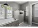 Bright bathroom featuring a modern tub with marble tile and a separate glass block shower with window shutters at 12117 Clear Harbor Dr, Tampa, FL 33626