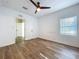 Bedroom with a ceiling fan, hardwood floors, a window and access to an adjacent room at 1403 E Laura St, Plant City, FL 33563