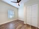 This bedroom features wood-look floors, a modern ceiling fan, a closet, and a window at 1403 E Laura St, Plant City, FL 33563