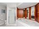 Spacious bathroom features tile flooring, a walk in shower, and a soaking tub with wood paneling at 14501 Brambie Ct, Tampa, FL 33624