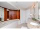 Large bathroom features granite countertops, double sinks, and a soaking tub with stylish wood paneling at 14501 Brambie Ct, Tampa, FL 33624