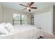 Bright bedroom with a ceiling fan, plush carpet flooring, a large window, and a closet with double doors at 14501 Brambie Ct, Tampa, FL 33624