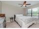 Comfortable bedroom with a ceiling fan, light neutral walls, and bright natural lighting at 14501 Brambie Ct, Tampa, FL 33624