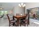 Dining area with modern chandelier, courtyard view, and adjacent living area at 14501 Brambie Ct, Tampa, FL 33624