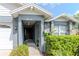 Close-up of a home's gray front entry showcasing stone accents, and neat shrubbery at 14501 Brambie Ct, Tampa, FL 33624