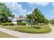 Charming home featuring lush landscaping, palm trees, and a well-manicured lawn, creating a welcoming curb appeal at 14501 Brambie Ct, Tampa, FL 33624