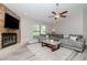 Living room features a stacked stone fireplace, large sectional sofa, and plush rug at 14501 Brambie Ct, Tampa, FL 33624
