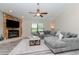 Spacious living room features a stone fireplace, ceiling fan, and large picture window at 14501 Brambie Ct, Tampa, FL 33624
