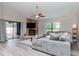 Bright living room with stone fireplace, modern fan, and sliding doors leading to the pool at 14501 Brambie Ct, Tampa, FL 33624