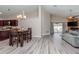 Open-concept living space with modern light gray plank flooring, dining area, and views of a pool at 14501 Brambie Ct, Tampa, FL 33624