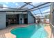 An inviting view of the beautiful screened pool with a lovely blue sky overhead at 14501 Brambie Ct, Tampa, FL 33624