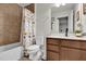 Neutral bathroom features a tub/shower, vanity with storage and decorative, animal-themed shower curtain at 14925 Promenade Pkwy, Odessa, FL 33556