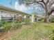 A view of the backyard shows trees and plants along the back of the home at 1655 S Highland Ave # G164, Clearwater, FL 33756