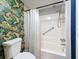 Tastefully decorated bathroom showcasing tropical-themed wallpaper, a toilet, and a shower with a hand-held shower head at 1655 S Highland Ave # G164, Clearwater, FL 33756