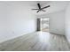Bright bedroom featuring sleek floors, ceiling fan and sliding glass door to outdoor space at 1655 S Highland Ave # G164, Clearwater, FL 33756
