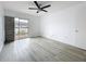 Bright bedroom featuring sleek floors, ceiling fan and sliding glass door to outdoor space at 1655 S Highland Ave # G164, Clearwater, FL 33756