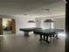 Spacious game room featuring two pool tables under vintage lamps and hardwood flooring at 1655 S Highland Ave # G164, Clearwater, FL 33756