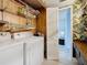 Convenient laundry area including a washer, dryer and open storage shelving, and a view of the adjacent bathroom at 1655 S Highland Ave # G164, Clearwater, FL 33756