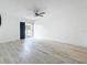 Bright living room featuring sleek floors, ceiling fan and sliding glass door to outdoor greenery at 1655 S Highland Ave # G164, Clearwater, FL 33756
