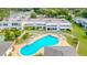 Aerial view of a community pool with lounge chairs and tables, surrounded by well-maintained lawns and buildings at 1655 S Highland Ave # G164, Clearwater, FL 33756
