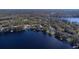 Picturesque lakefront homes with private docks and mature trees surrounding a serene, expansive lake from above at 16573 Hutchison Rd, Odessa, FL 33556