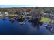 Stunning lakefront property with multiple docks, lush trees, and serene water views from an aerial perspective at 16573 Hutchison Rd, Odessa, FL 33556