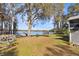 Lakeside backyard with mature trees and a tire swing for endless fun, with a dock and boat ramp for lake adventures at 16573 Hutchison Rd, Odessa, FL 33556