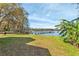 Expansive backyard view with a wooden dock extending into the serene lake waters, perfect for outdoor activities at 16573 Hutchison Rd, Odessa, FL 33556