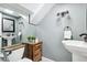 Bathroom featuring two vanities, a toilet, decorative mirror and unique wall lighting at 16573 Hutchison Rd, Odessa, FL 33556