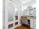 Bathroom vanity features a large mirror, vanity, chair and modern wall lighting at 16573 Hutchison Rd, Odessa, FL 33556