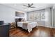 This bedroom features hardwood floors, a ceiling fan, natural light and neutral paint, creating a serene atmosphere at 16573 Hutchison Rd, Odessa, FL 33556