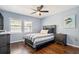 Relax in this cozy bedroom, complete with hardwood floors, a ceiling fan, natural light and tasteful decor at 16573 Hutchison Rd, Odessa, FL 33556