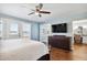Bright bedroom featuring hardwood floors, a ceiling fan, and ensuite bathroom with a lake view at 16573 Hutchison Rd, Odessa, FL 33556