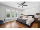 Unwind in this bedroom with hardwood floors, ceiling fan, natural light from plantation shutters, and a relaxing ambiance at 16573 Hutchison Rd, Odessa, FL 33556