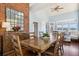 Dining room with brick accent wall, wooden table with seating for eight, and water views at 16573 Hutchison Rd, Odessa, FL 33556