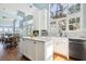 Bright kitchen with a central island, white cabinets, marble countertops, and natural light at 16573 Hutchison Rd, Odessa, FL 33556
