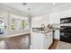 Modern kitchen with white cabinetry, granite countertops, stainless steel appliances, and an adjacent dining area at 16573 Hutchison Rd, Odessa, FL 33556