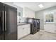 Laundry room features front loading washer and dryer, plenty of cabinets, and a stainless steel refrigerator at 16573 Hutchison Rd, Odessa, FL 33556